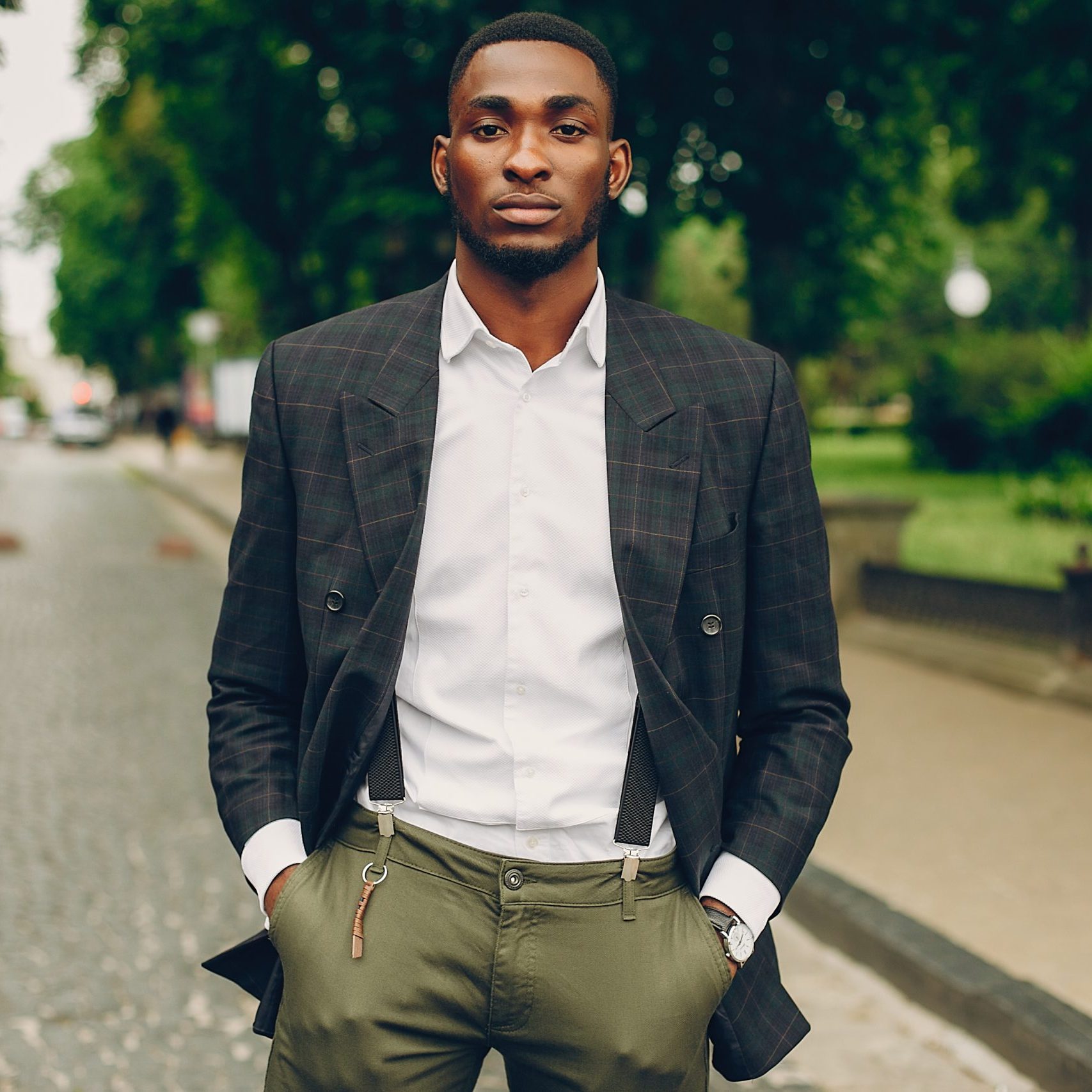 The guy standing in a city. The man in a suit. Stylish black man