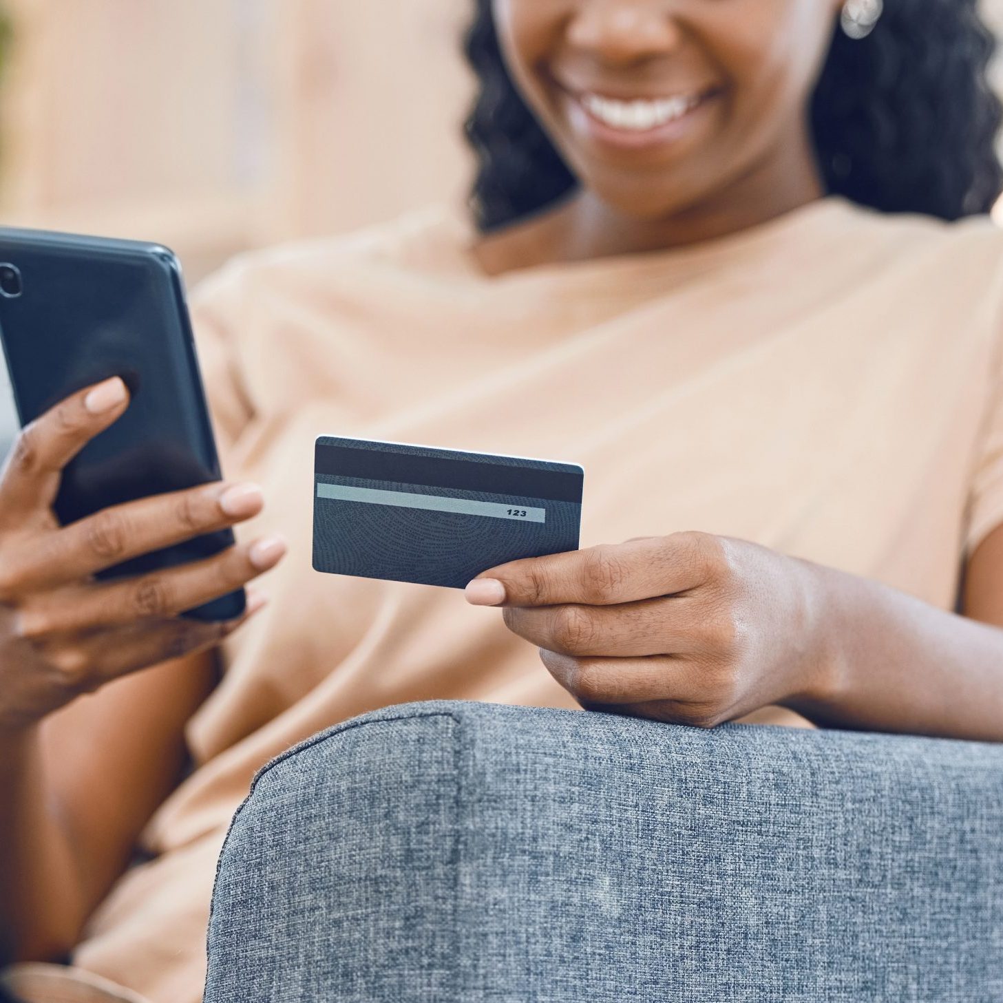 Black woman, online shopping and ecommerce phone payment on credit card, mobile money and internet finance on home sofa. Closeup of happy african person, cellphone banking and easy fintech technology.